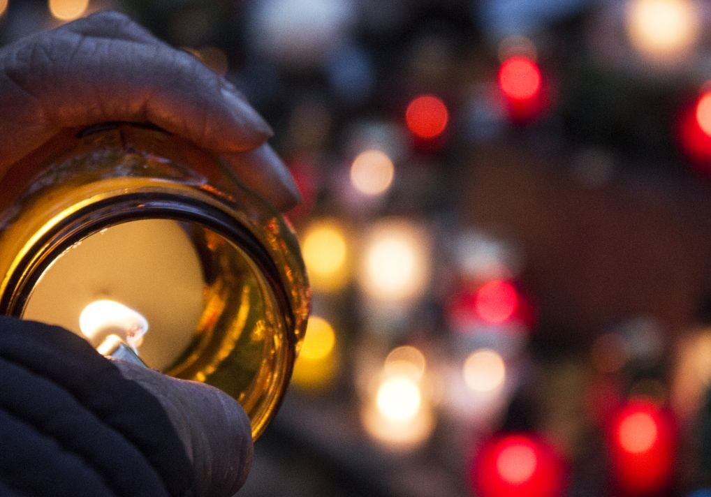 Female lights candle to put on a grave